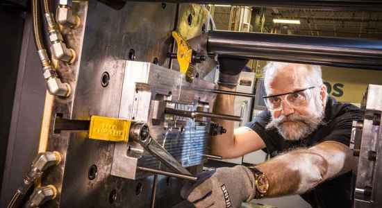 Man using injection moulding machine