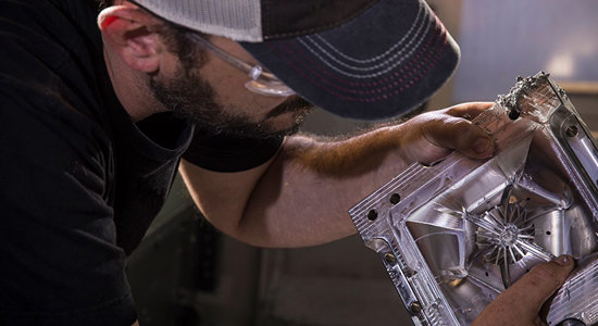 A person inspecting a high-precision aluminum mold